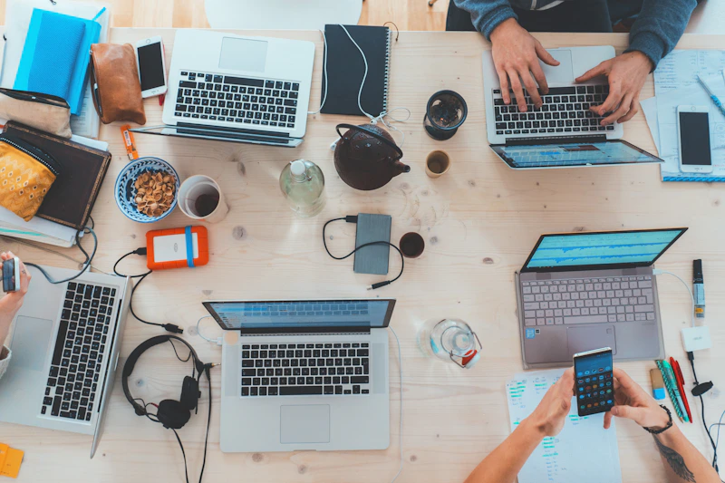 Estação de trabalho com telas e teclado em ambiente colaborativo
